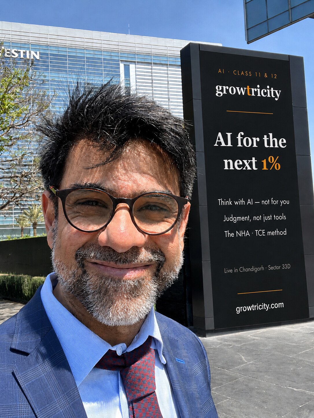 Ashish Punj, Founder and Lead Instructor, smiling beside a Growtricity billboard